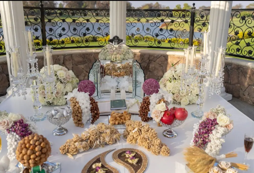 Full Sofreh Aghd ceremonial table with mirror, florals, and traditional elements